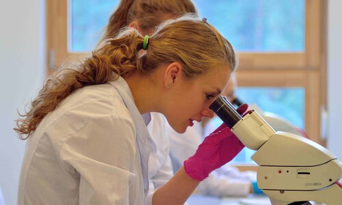 Studentka pracująca przy mikroskopie w czasie zajęć z mikrobiologii